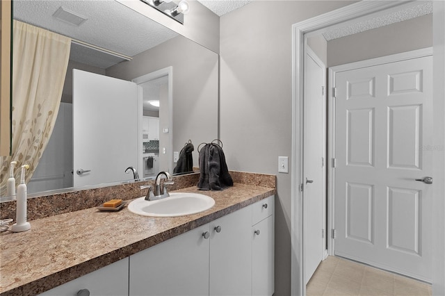 bathroom with visible vents, a textured ceiling, and vanity