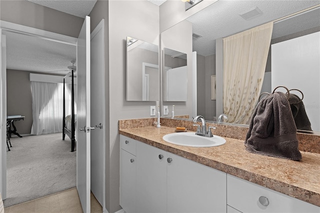 bathroom with vanity, visible vents, and a textured ceiling