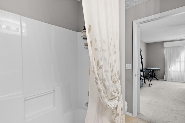 full bath with shower / tub combo and a textured ceiling