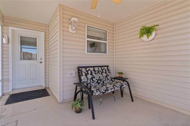 view of exterior entry with a porch and a ceiling fan