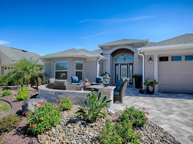 view of patio / terrace featuring outdoor lounge area, driveway, and an attached garage