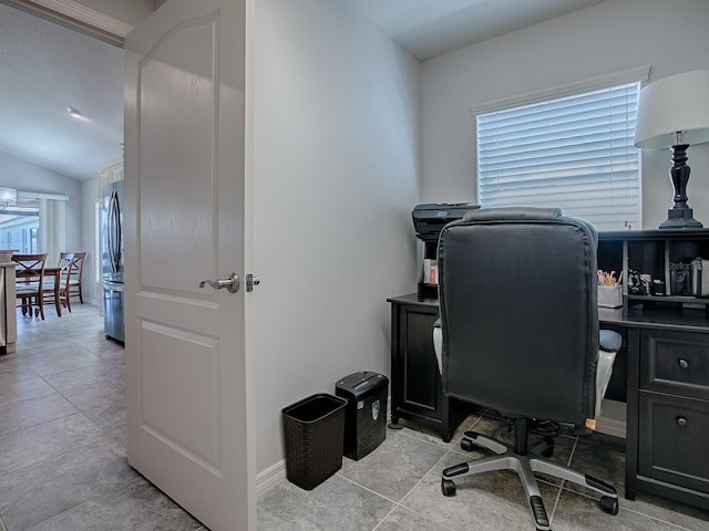 home office with light tile patterned floors, baseboards, and lofted ceiling