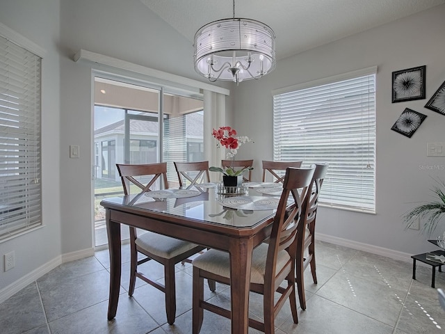 dining room with light tile patterned floors, a notable chandelier, baseboards, and vaulted ceiling