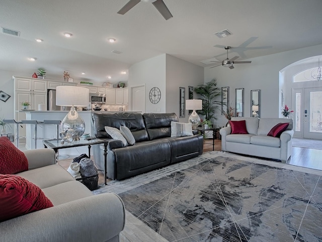 living area featuring visible vents, arched walkways, and ceiling fan