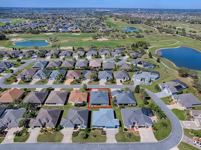 bird's eye view featuring golf course view, a water view, and a residential view