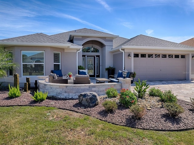 view of front of home featuring a shingled roof, a garage, driveway, and stucco siding