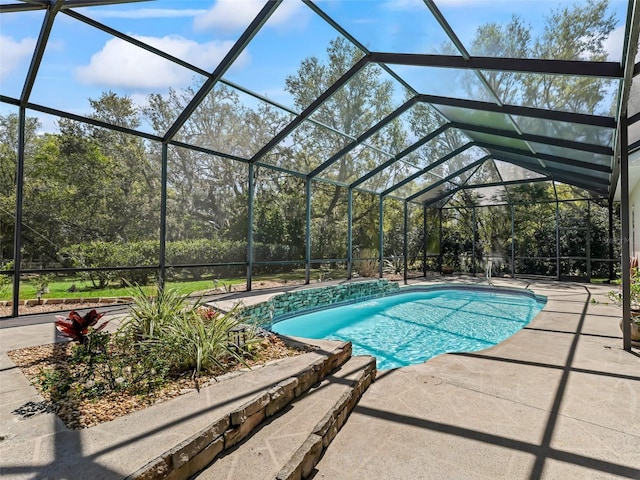 pool with a patio area and glass enclosure