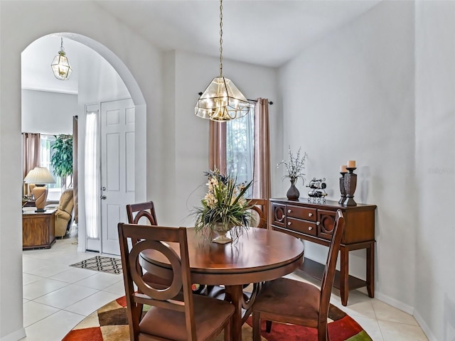 dining space featuring a chandelier, arched walkways, and light tile patterned flooring