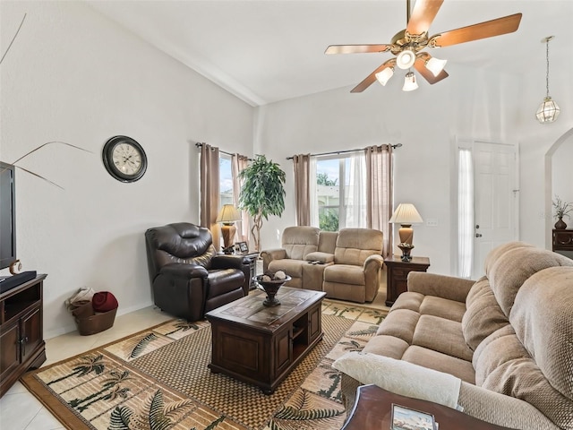 living area featuring arched walkways, a high ceiling, a ceiling fan, and light tile patterned flooring