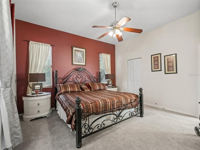 bedroom with a closet, baseboards, a ceiling fan, and carpet flooring