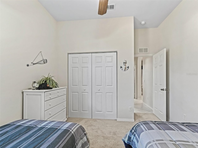 bedroom with a closet, light colored carpet, baseboards, and visible vents