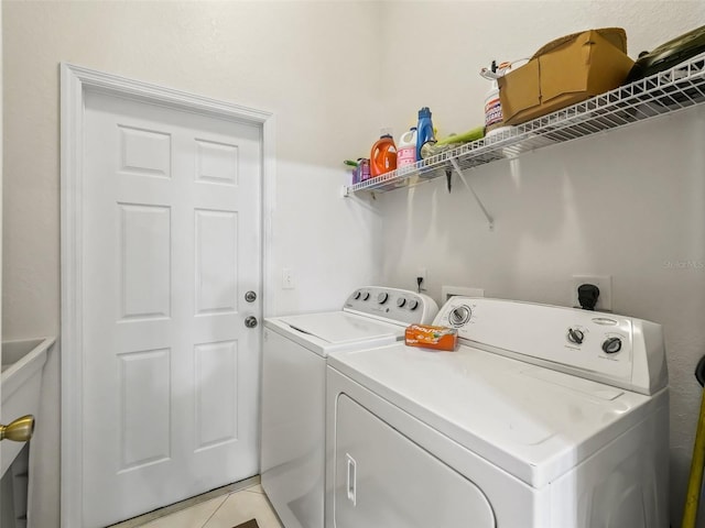 laundry area featuring washer and clothes dryer, light tile patterned floors, and laundry area