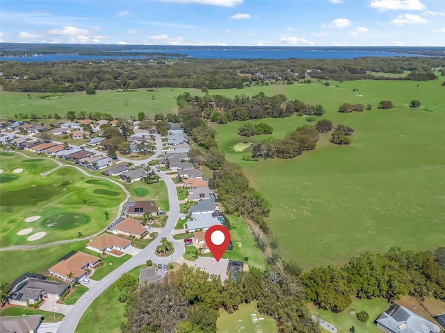 drone / aerial view with golf course view, a residential view, and a water view
