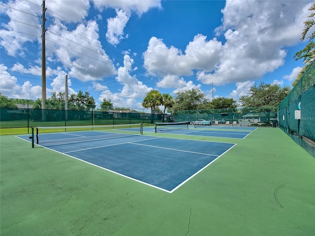 view of tennis court with community basketball court and fence