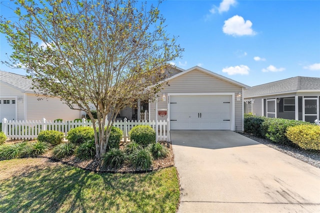 single story home with concrete driveway, a garage, and a fenced front yard