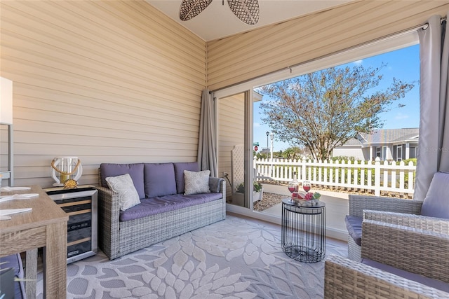 sunroom / solarium featuring wine cooler and a ceiling fan