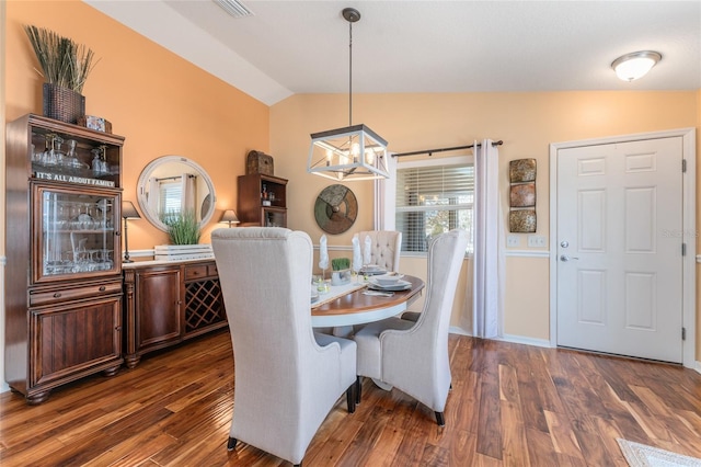 dining room with visible vents, an inviting chandelier, lofted ceiling, and dark wood-style flooring