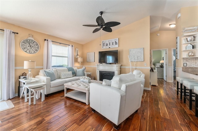 living area featuring a fireplace, lofted ceiling, a ceiling fan, and dark wood-style flooring