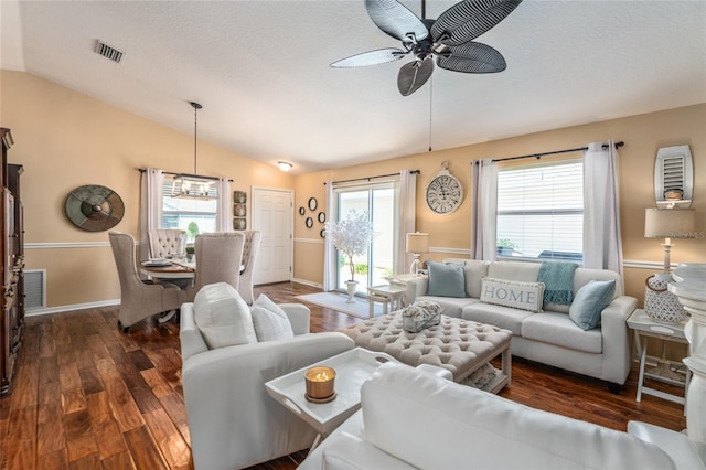 living room featuring lofted ceiling, wood finished floors, a ceiling fan, and visible vents