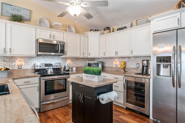 kitchen with wine cooler, white cabinets, stainless steel appliances, and tasteful backsplash