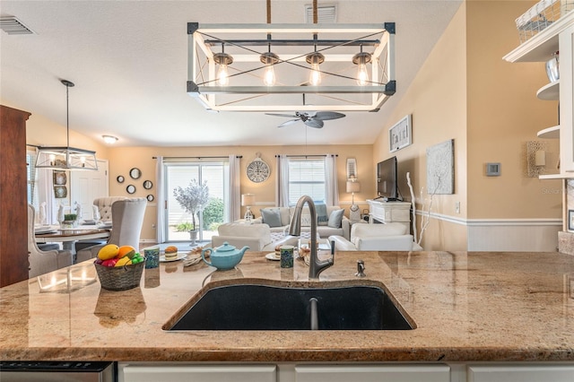 kitchen with a sink, visible vents, open floor plan, and ceiling fan