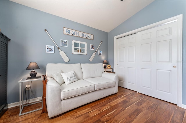 living area featuring baseboards, lofted ceiling, and wood finished floors