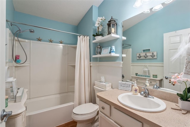 full bathroom with wainscoting, shower / bath combination with curtain, toilet, and vanity