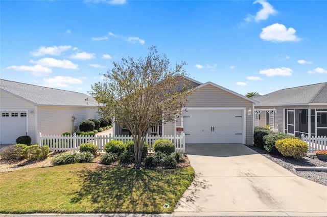 ranch-style home featuring a fenced front yard, driveway, and an attached garage