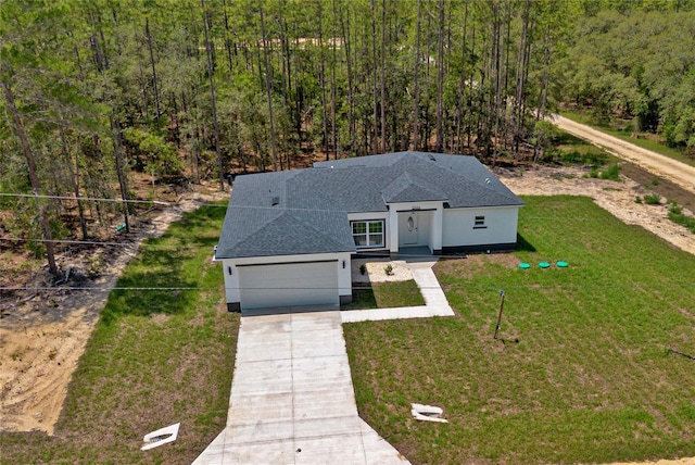 12444 SW 76th Ln, Dunnellon, FL 34432 - view of front of home featuring driveway, a front yard, roof with shingles, stucco siding, and an attached garage