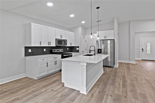 12444 SW 76th Ln, Dunnellon, FL 34432 - kitchen featuring stainless steel appliances, decorative backsplash, white cabinetry, decorative light fixtures, and light countertops