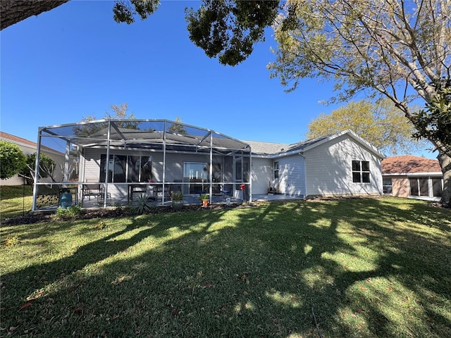 back of property featuring glass enclosure and a lawn