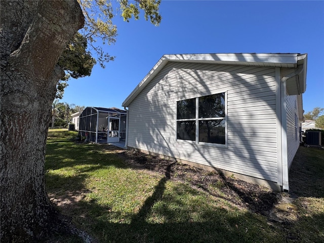 view of home's exterior featuring a lawn, central AC unit, and a lanai