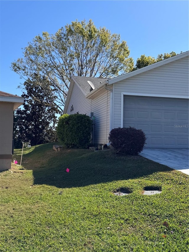 view of property exterior featuring a yard, a garage, and driveway