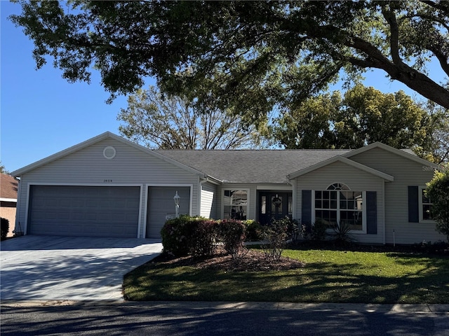 ranch-style home featuring a front yard, an attached garage, and driveway