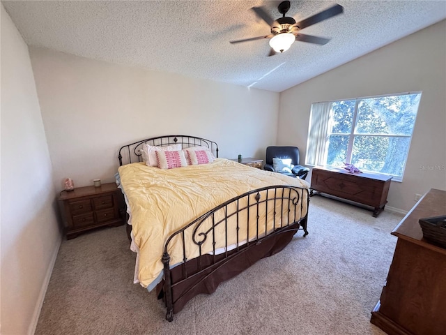 bedroom featuring ceiling fan, lofted ceiling, carpet, and a textured ceiling