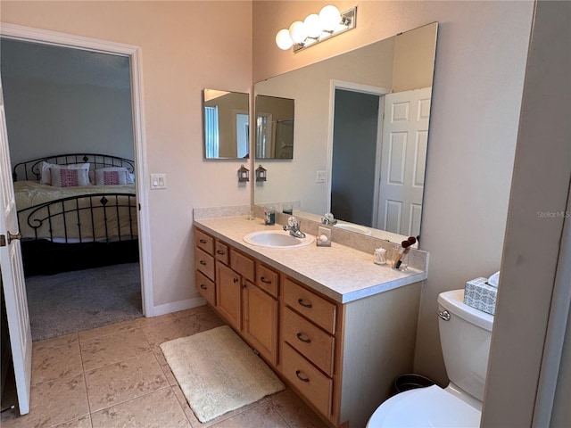 bathroom with vanity, baseboards, tile patterned flooring, toilet, and connected bathroom