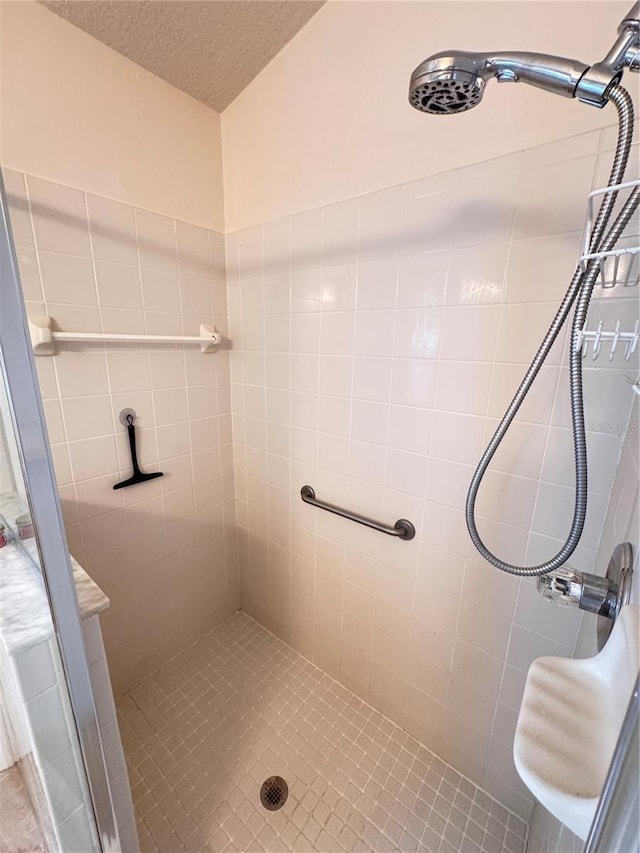 bathroom featuring a stall shower and a textured ceiling