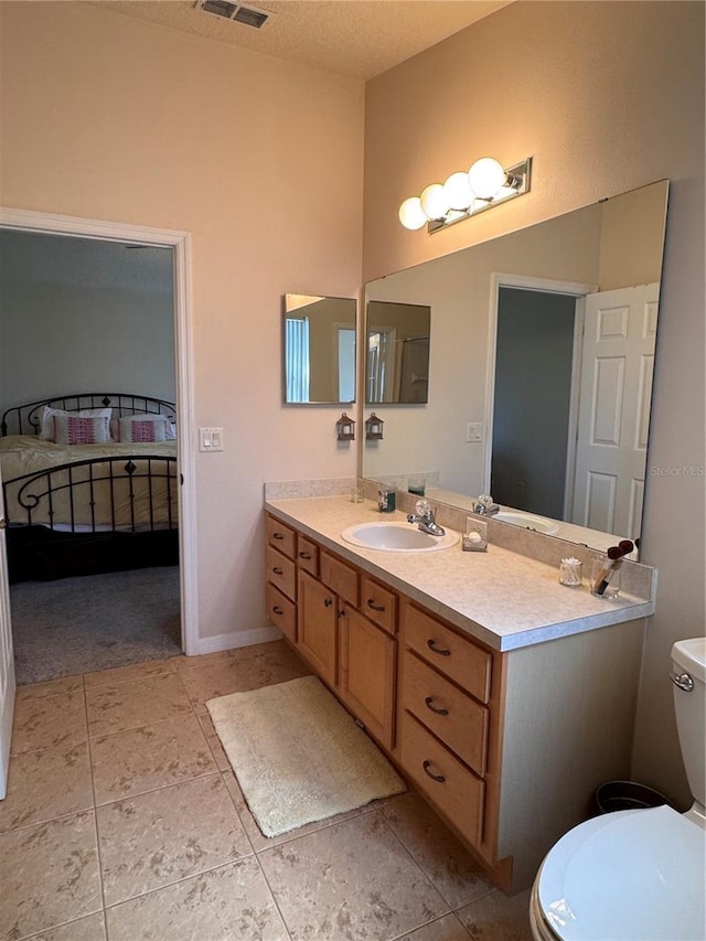 ensuite bathroom featuring vanity, ensuite bath, toilet, and a textured ceiling