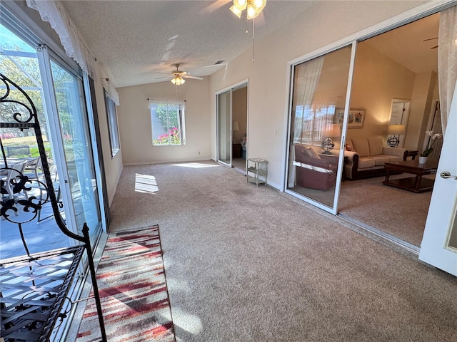 unfurnished sunroom featuring a ceiling fan and vaulted ceiling