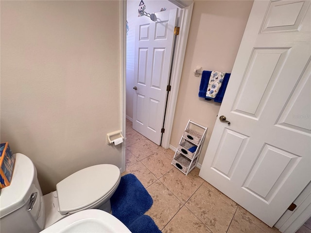 half bathroom with tile patterned floors, baseboards, and toilet