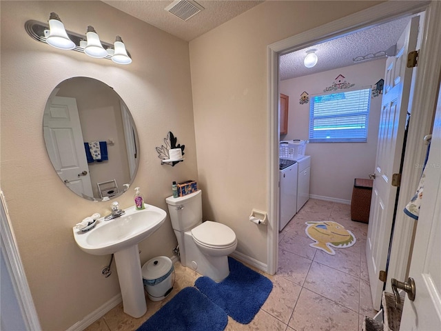 bathroom featuring visible vents, tile patterned flooring, a textured ceiling, washer and dryer, and toilet