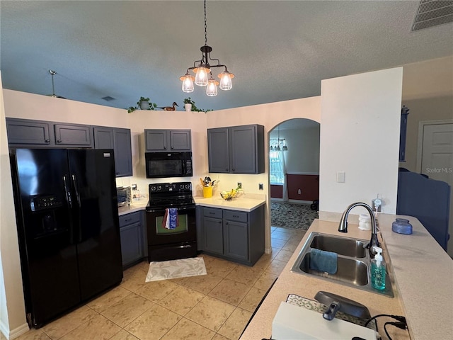 kitchen featuring visible vents, a notable chandelier, black appliances, a sink, and arched walkways