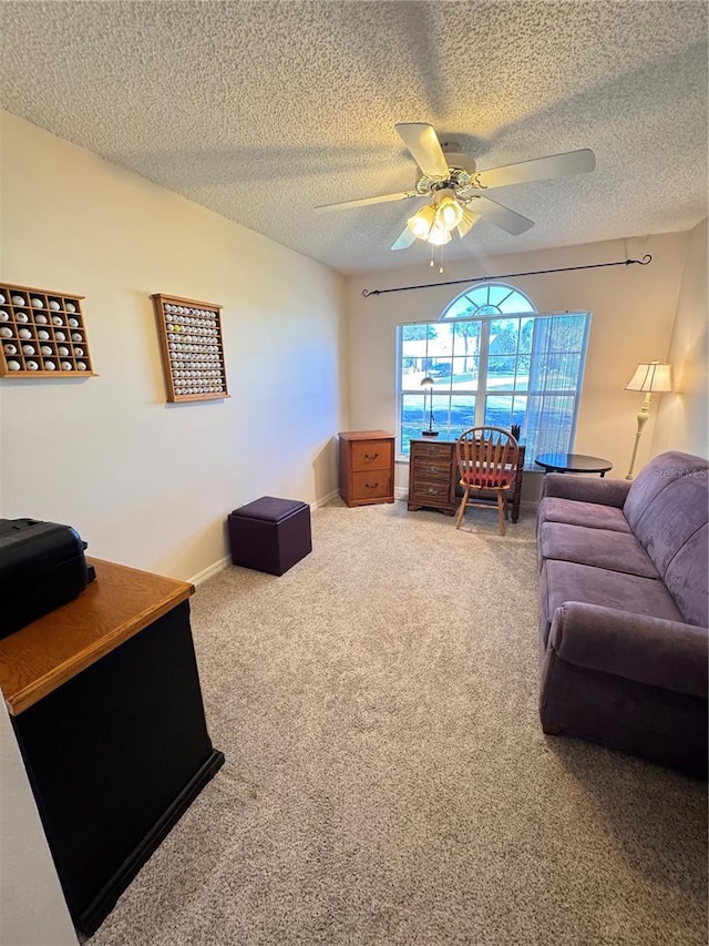 carpeted living room featuring a ceiling fan, baseboards, and a textured ceiling