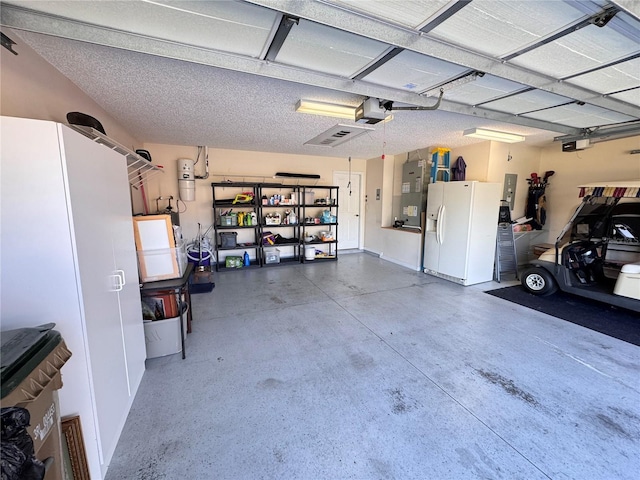 garage featuring electric panel, white refrigerator with ice dispenser, a garage door opener, and heating unit