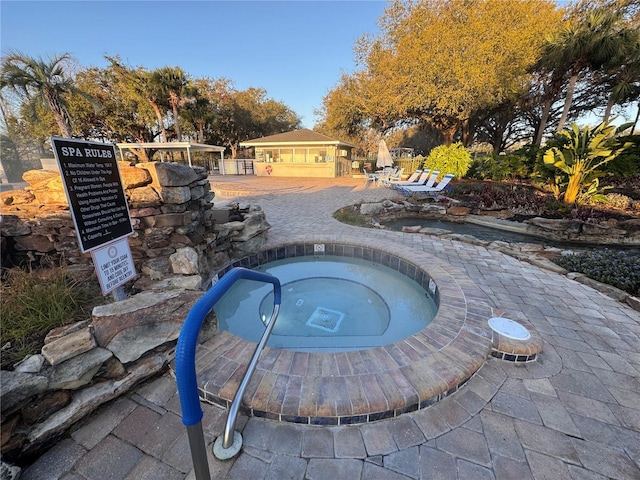 view of swimming pool featuring a patio area and a hot tub