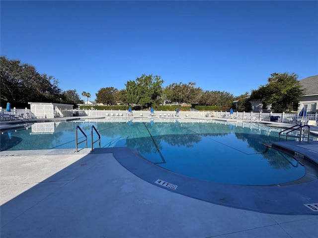 community pool featuring a patio and fence