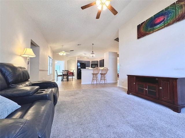24614 Stillridge Ct, Leesburg, FL 34748 - living room featuring light tile patterned floors, a textured ceiling, light colored carpet, a ceiling fan, and lofted ceiling