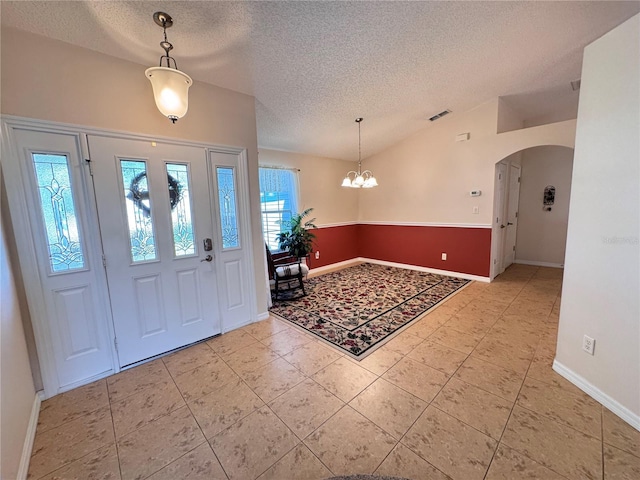 24614 Stillridge Ct, Leesburg, FL 34748 - tiled entrance foyer with visible vents, arched walkways, a notable chandelier, and a textured ceiling