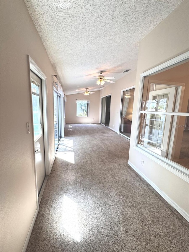 24614 Stillridge Ct, Leesburg, FL 34748 - carpeted spare room featuring a textured ceiling, a ceiling fan, vaulted ceiling, visible vents, and baseboards