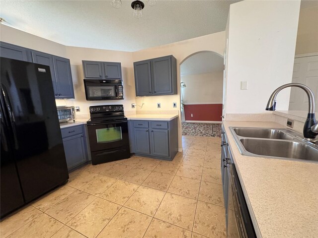24614 Stillridge Ct, Leesburg, FL 34748 - kitchen featuring light tile patterned floors, light countertops, black appliances, arched walkways, and a sink